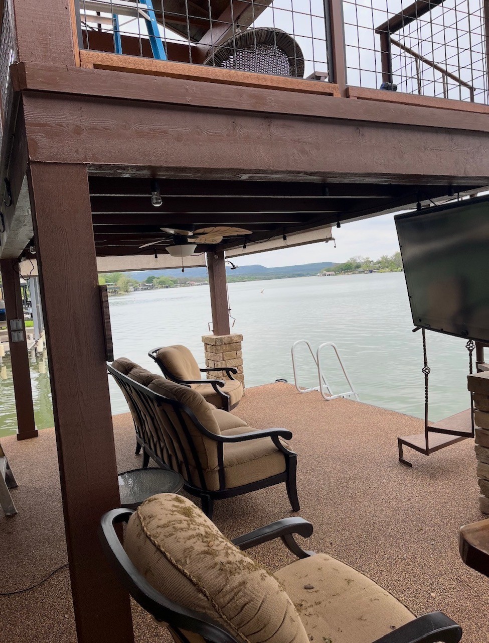 Covered lakefront dock seating area with an upper deck